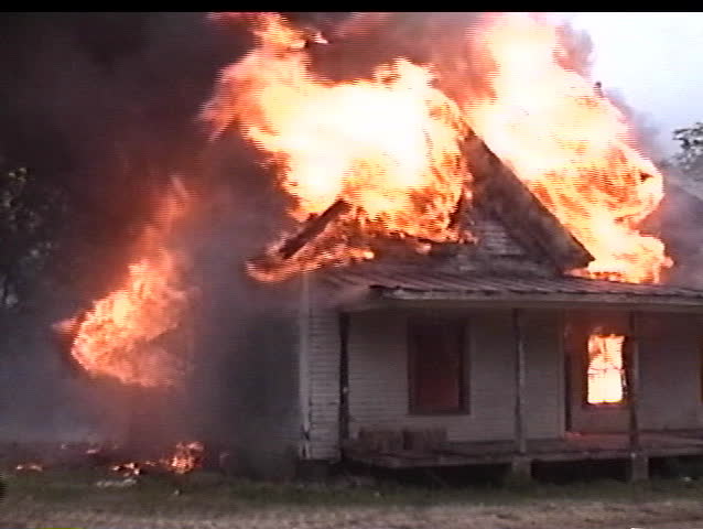 Fireman walks in front of house fire
