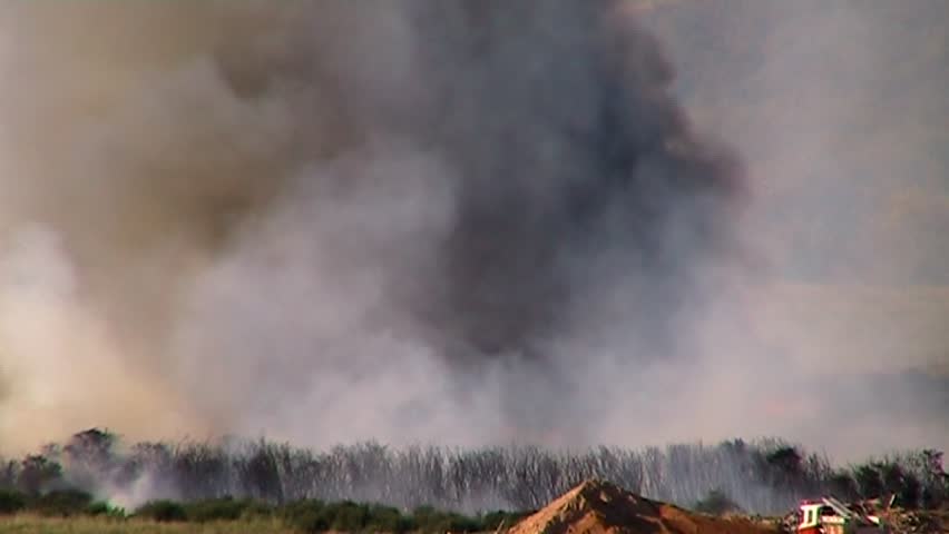 time lapse sequence of a grass fire with fire units attending