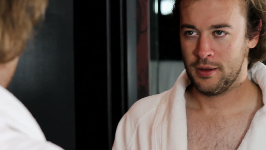 Hip young man psychs himself in front of the mirror