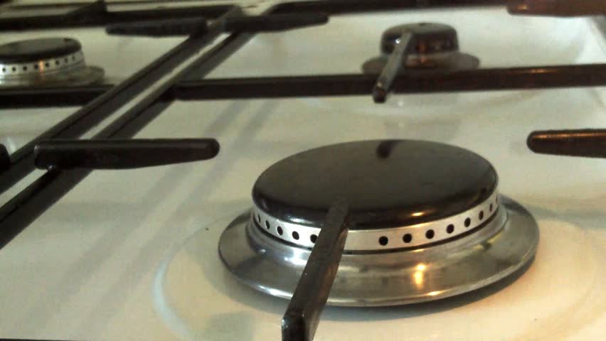Lighting a flame on a burner of a gas cooker gas.