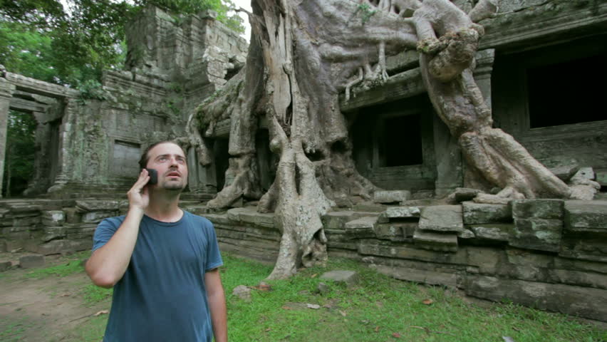 Young man talking phone in preah khan temple, Angkor