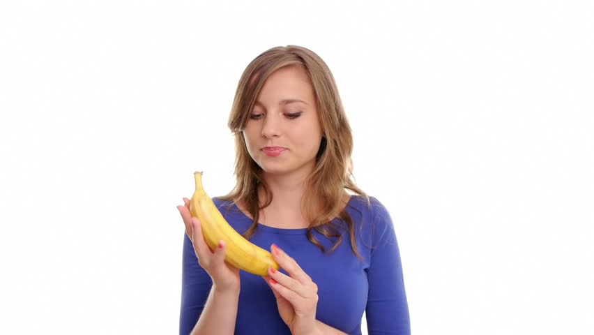 woman peeling and eating a banana in starts laughing