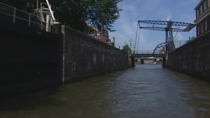 AMSTERDAM - JULY 2002 canal sailing through open lock sluice in canal
