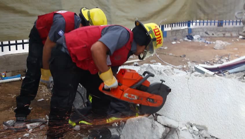 HOLON, ISRAEL - OCTOBER 21: Firefighter cuts steel to rescue earthquake casualty victims to rescue earthquake casualty victims during earthquake simulation drill in Holon Israel, October 21, 2012