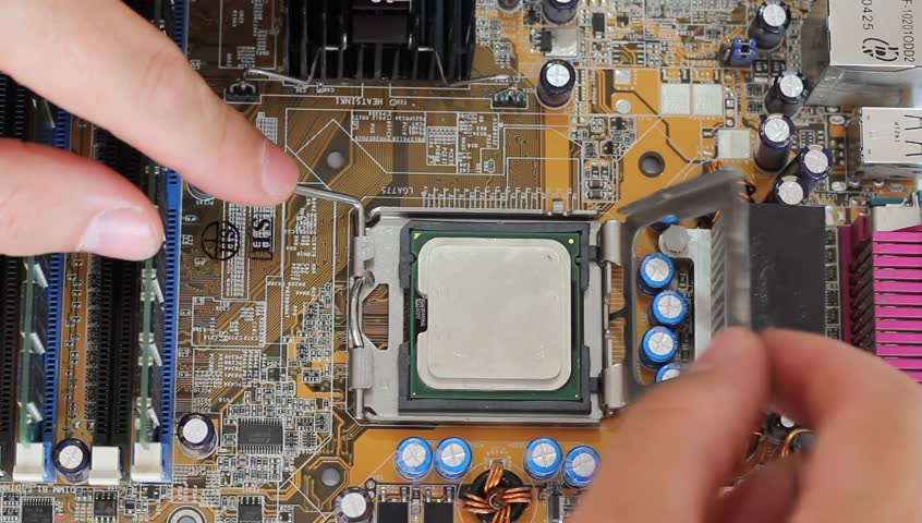 Man pulls out a computer processor from the motherboard. 