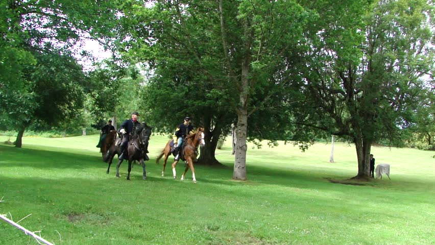 PORT GAMBLE, WA - JUN 20 -  	Union and Confederate cavalry ride through trees and across field		before a mock battle at Port Gamble WA on Jun 20, 2009.

