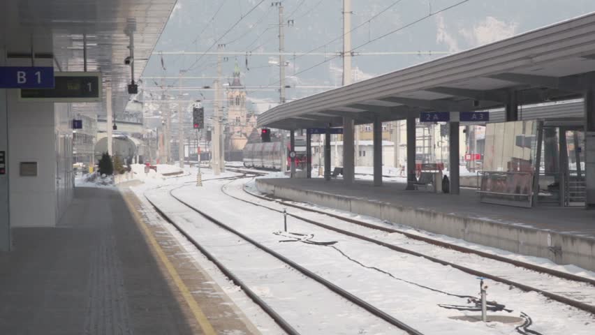Train ride away from railway station at winter day in village near mountains