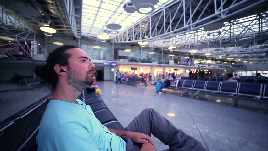 young man waiting his flight in airport lounge, profile shot