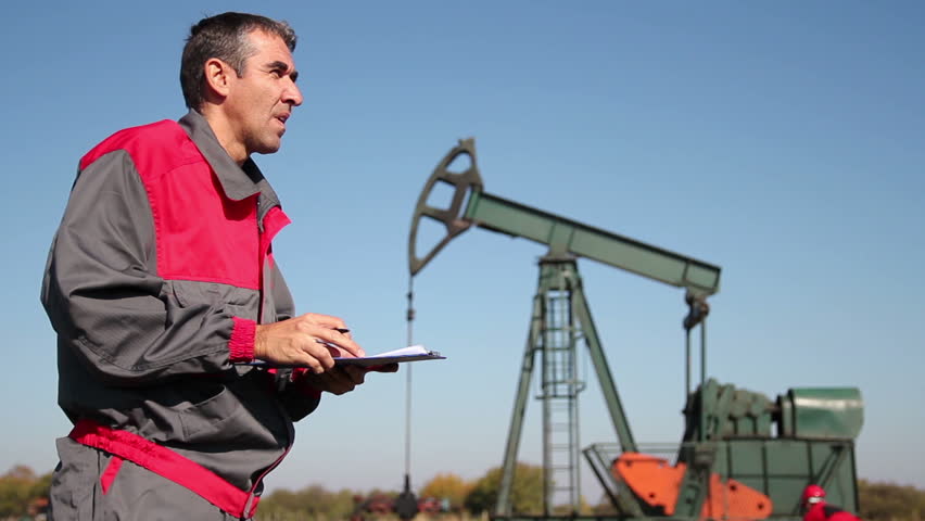Engineer Giving Orders to Oil Worker.
Oil workers at well pump jack site. HD1080p.