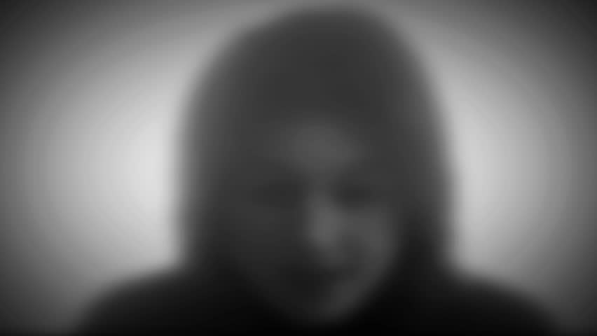 Video head shot of blurry, anonymous woman in  interview. Sitting in middle of image, black and white with no audio looking sad, zoom into focus on eyes, depressed, ashamed of drug use. 