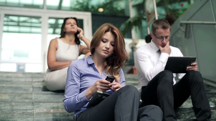 Young business people working on stairs by office building
