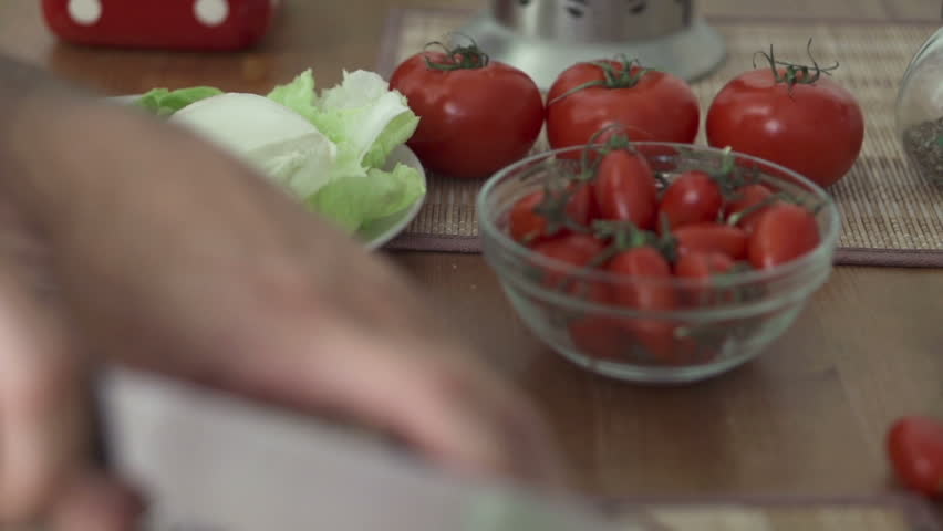 Hand cutting block of ham with knife, slow motion shot at 240fps
