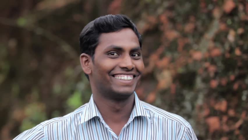 Indian young man shows expressions outdoors. Dolly shot with copyspace. 