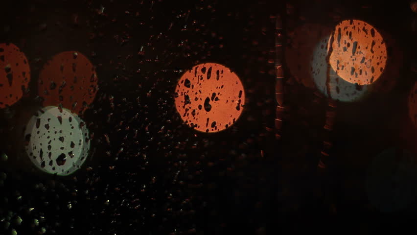 Raindrops on glass window at night