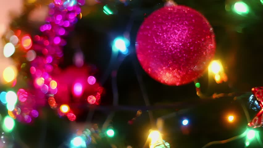 Colorful adornment with garland on fir tree, closeup view in motion