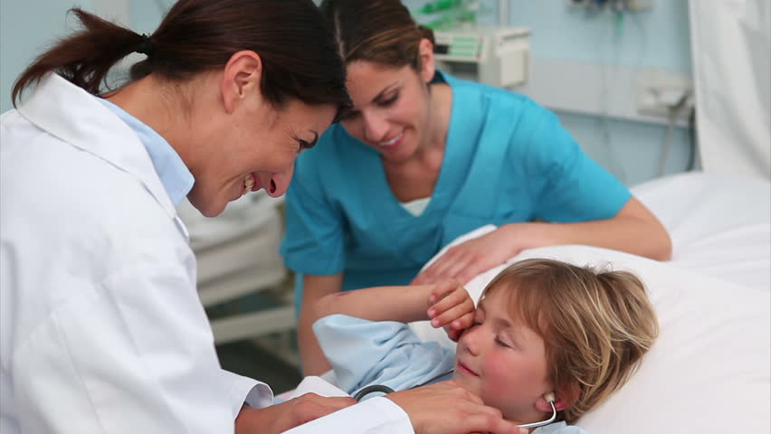 Doctor examining a child in hospital ward