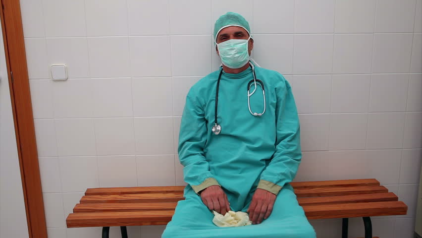 Video of an annoyed surgeon sitting on a bench in locker room