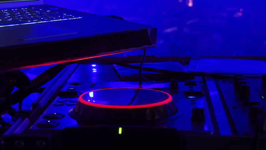 DJ equipment, people dancing background against blue light. Disc jockey. Blue lights.