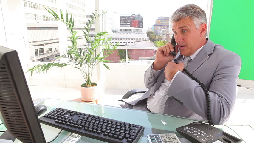 Businessman annoyed as he ends a call in an office