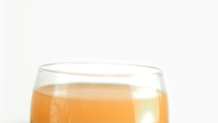 Orange juice drops falling in super slow motion into orange juice