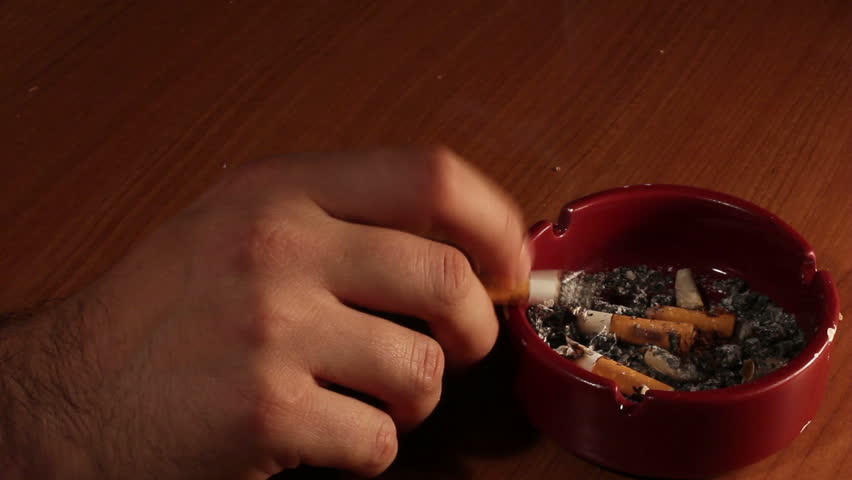 Detail of Male hand smoking Cigarette in ashtray
