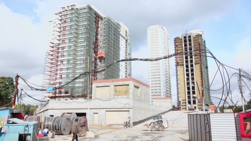 MOSCOW - OCTOBER 7: Loader ride and labourers walk at construction site of dwelling complex Elk Island on October 7, 2011 in Moscow, Russia. Complex includes 1334 apartments of 40-143 square meters