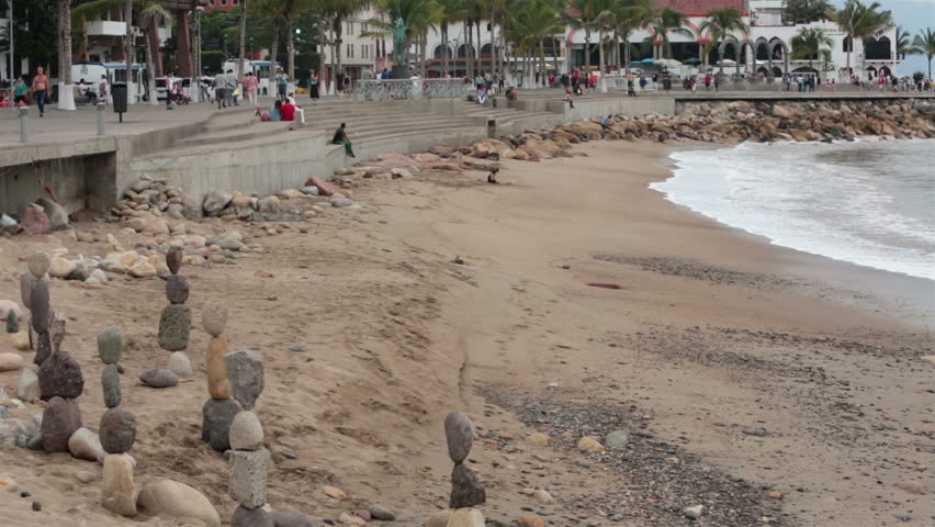 PUERTO VALLARTA, MEXICO NOV 2012: Tourism attraction and income for locals. Malecon Boardwalk beach rocks. Tourist area shore of Banderas Bay, Pacific Ocean. Work for tips and recognition.
