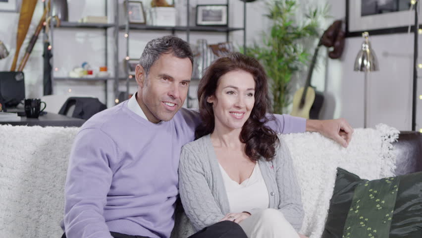 A young girl comes to sit in between her parents at home and begins to read to them. In slow motion.