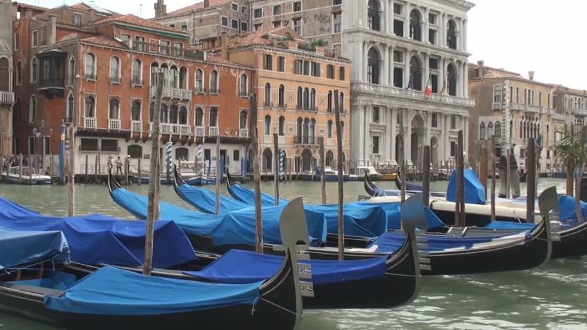 Gondolas moored on the Grand Canal in Venice with palaces in the background
