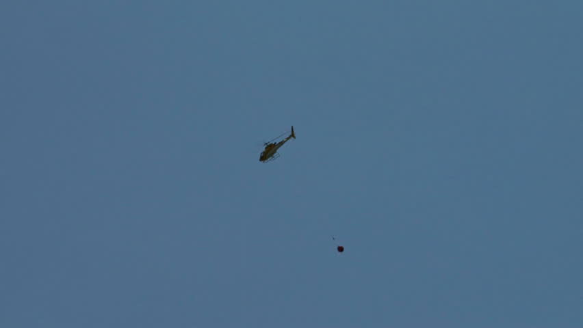 The chopper swinging around after arriving at the river, probably aligning the craft so as to take advantage of the prevailing wind as it refills the hanging bucket.