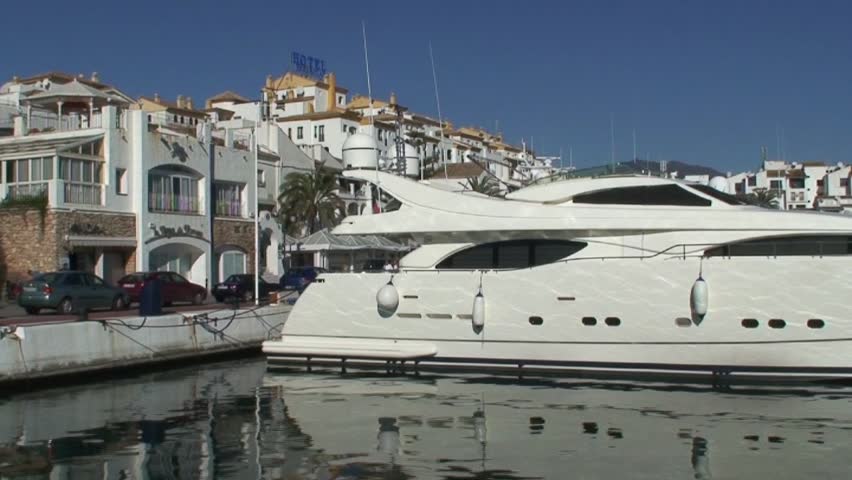 Panning shot of large white expensive yachts in Puerto Banus port in Spain on the Costa del Sol
