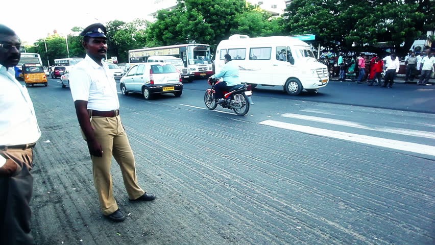 INDIA - JULY 2012: Locked-on shot of a traffic policeman controlling traffic on a busy road, Chennai, Tamil Nadu, India
