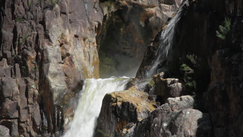 Close up of top of raging waterfall & close up tilt of raging waterfall