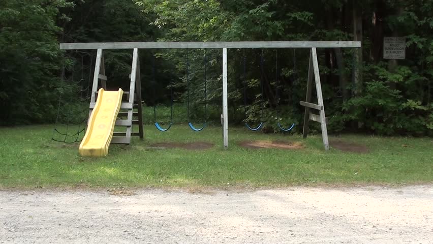 Empty Swings Swaying At Playground