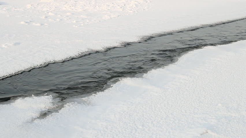 dangerous washout   in the ice of frozen river