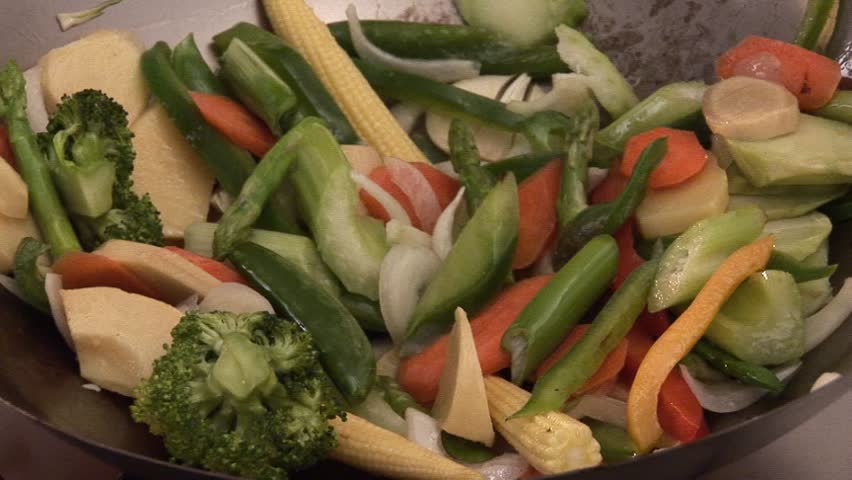 Adding sprouts to vegetables in a wok