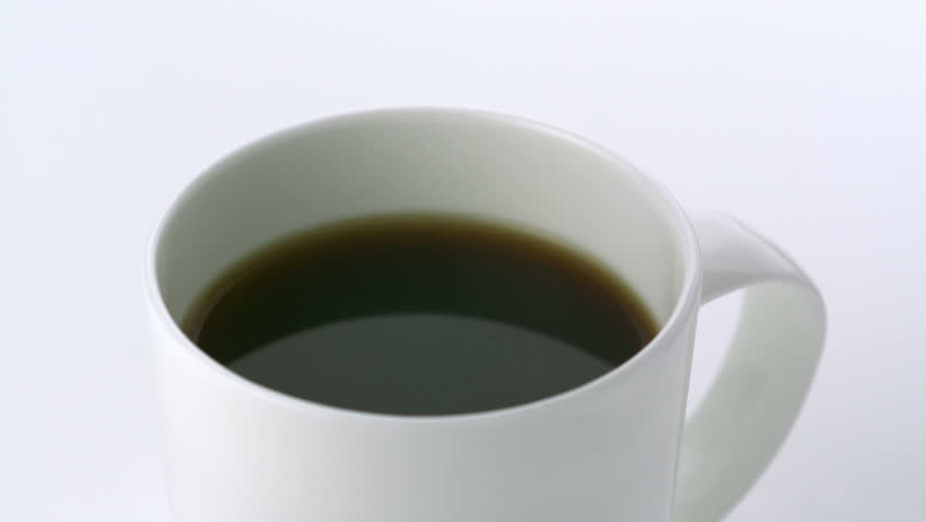 Pouring coffee into cup on white background shooting with high speed camera.
