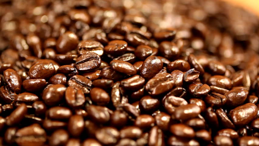 Hands going through coffee beans