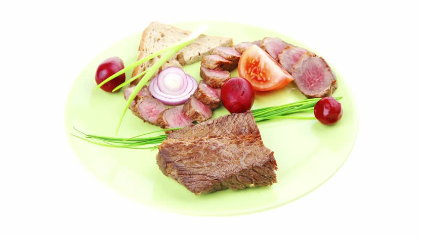 main course : roast red meat slices served on green plate with tomatoes and sprouts isolated on white background