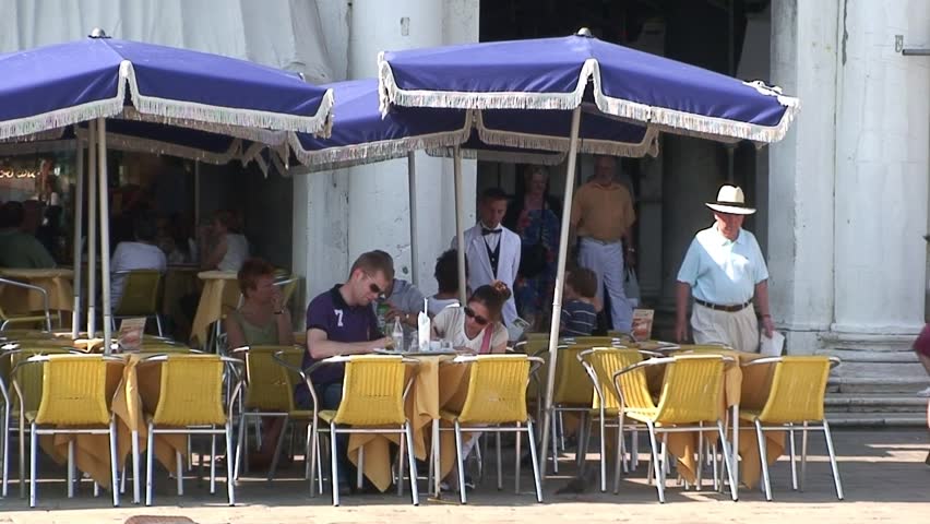 VENICE, ITALY - CIRCA 2011: Many tourists passing a tourist cafe in St Marks Square in Venice.