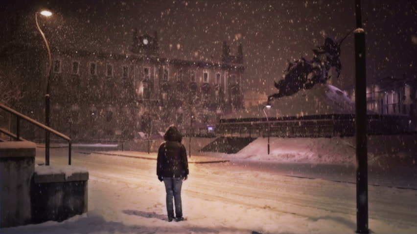 Person standing under the snowfall at the principal square of Monza, Italy