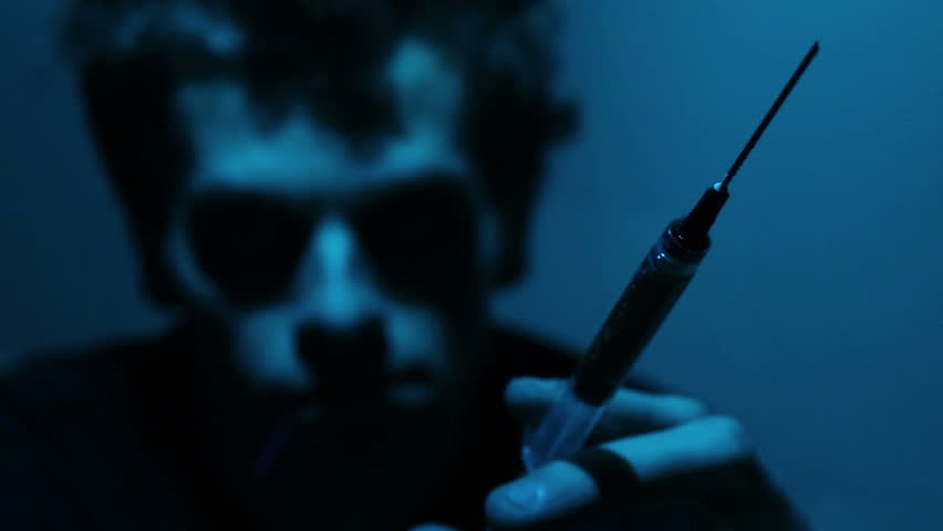 Man holds syringe.  