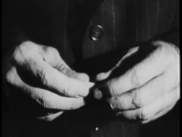 Close-up of man's hands inserting rolled paper into capsule