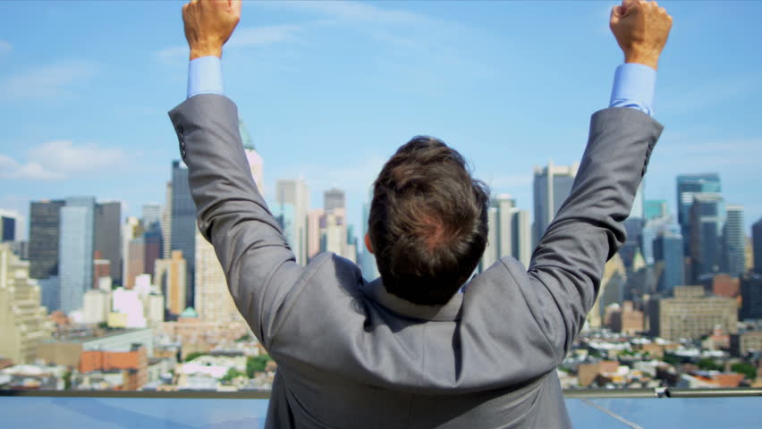 Hands up of Caucasian smart male celebrating business success on rooftop overlooking Manhattan shot on RED EPIC