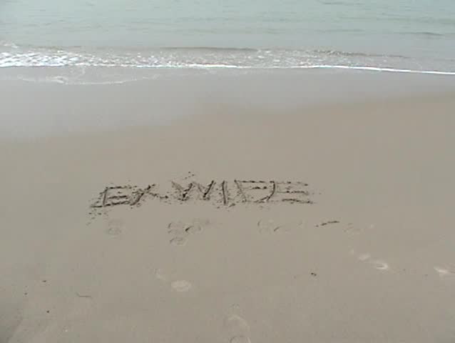 the word "EX WIFE" is washed away by the tide on the beach