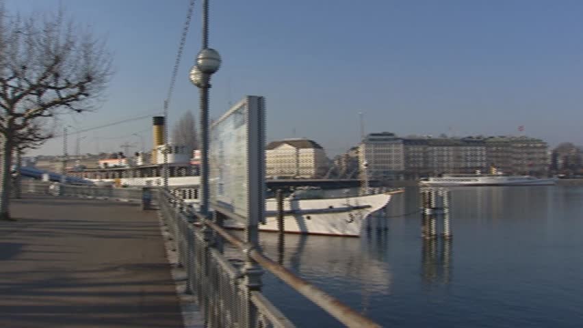 GENEVA, SWITZERLAND: boulevard pan Lake Geneva + city in background