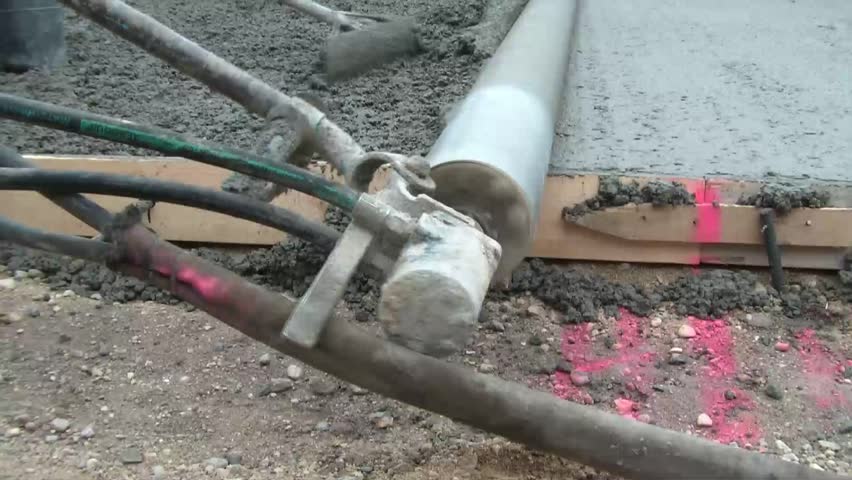 Close up shot of spinning concrete smoothing machine that almost completely finishes wet material onto new driveway.