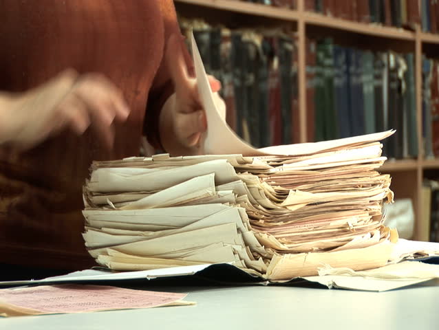 woman's looking for something among old paper documents in file