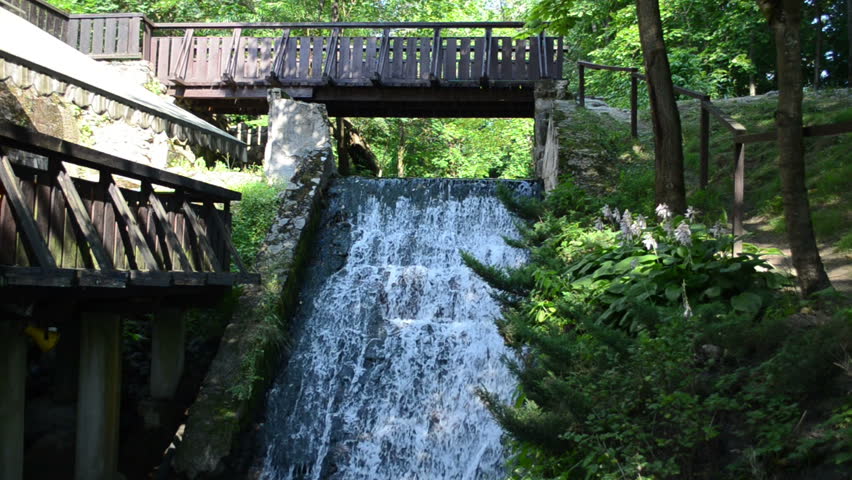 brook stream flow run through old retro water mill bridge cascade.