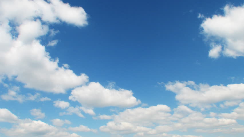 Time lapse clip of white fluffy clouds over blue sky